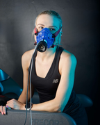 Person wearing a blue respiratory mask in a dark setting