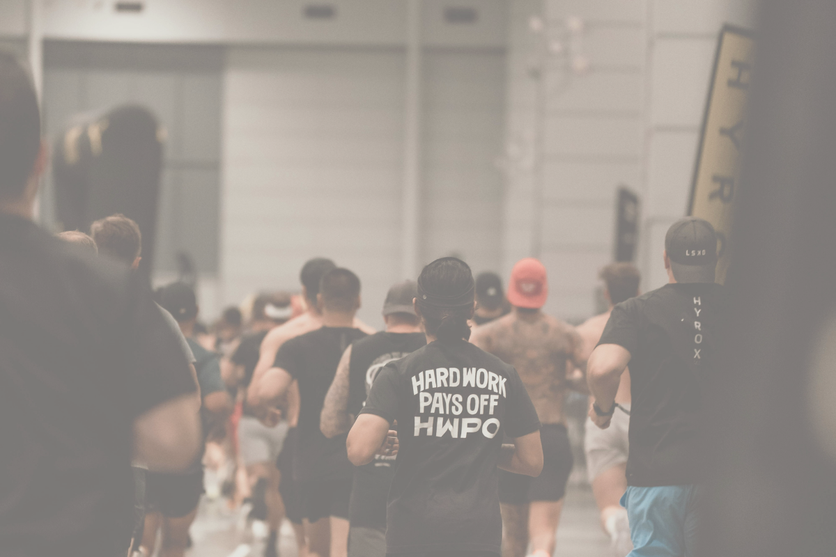 Group of people walking with one person wearing a shirt with 'Hard Work Pays Off HWPO' text.